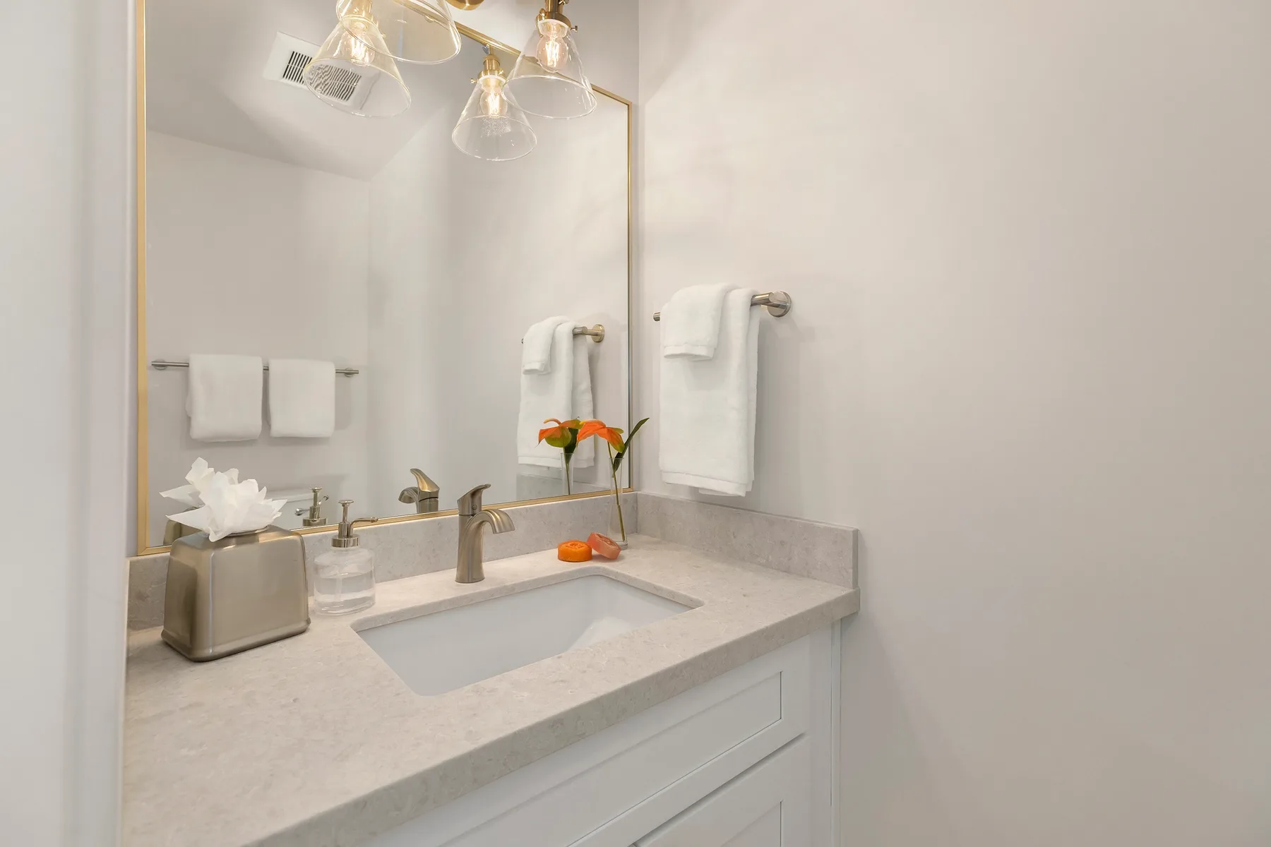 Un tocador de baño con lavabo, espejo y toallas dobladas.
