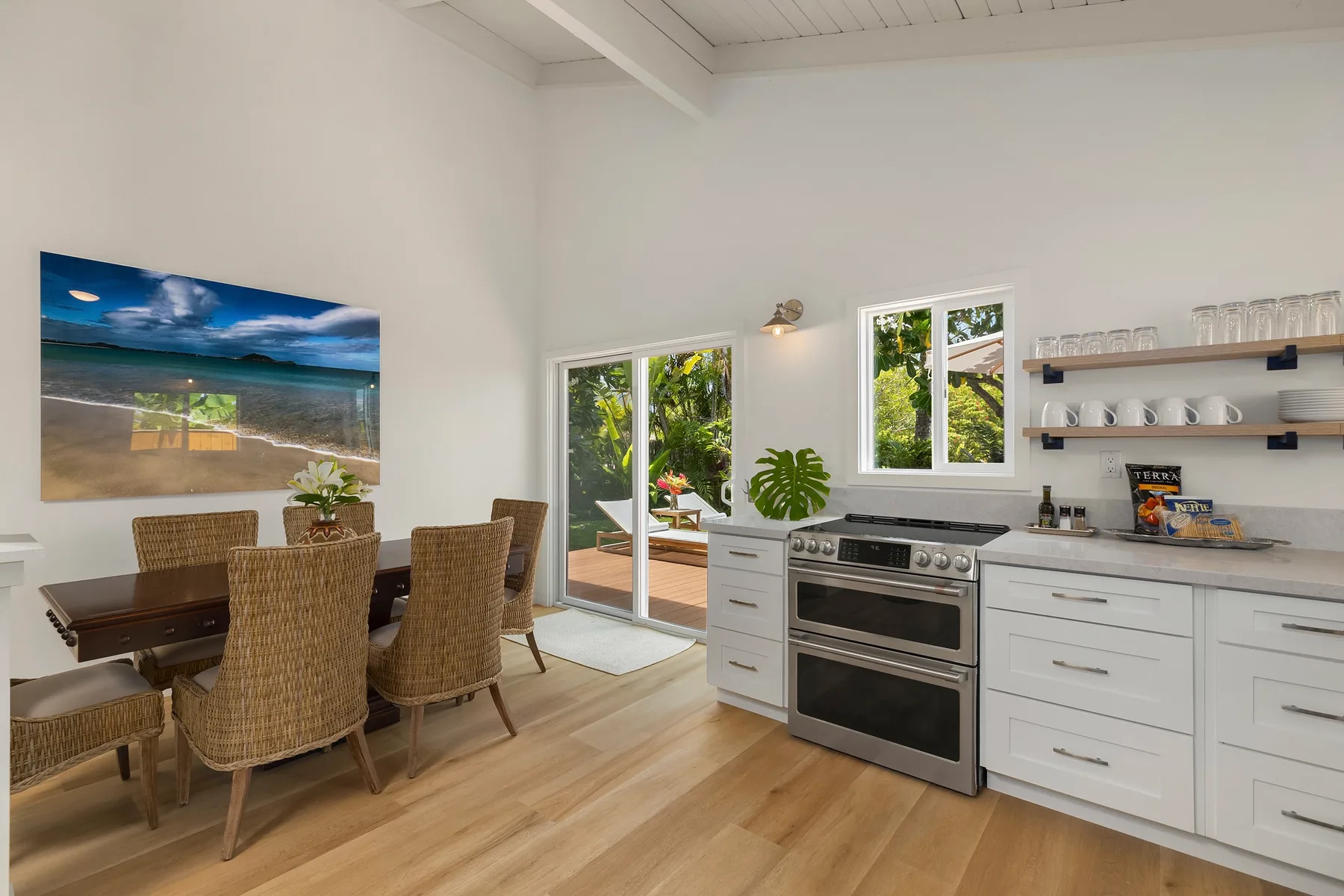 A bright kitchen and dining area with white cabinets and a wooden table.