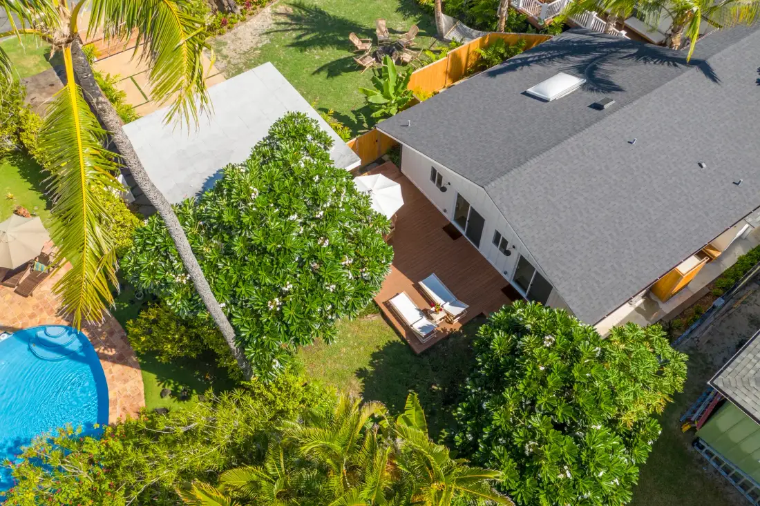 Vista aérea de una casa con patio y piscina entre vegetación tropical.