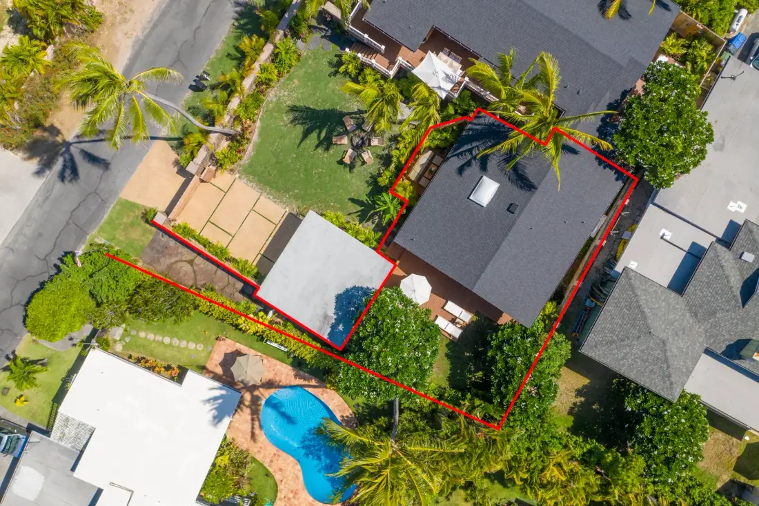 Vista aérea de una casa y su jardín, con una piscina cercana.