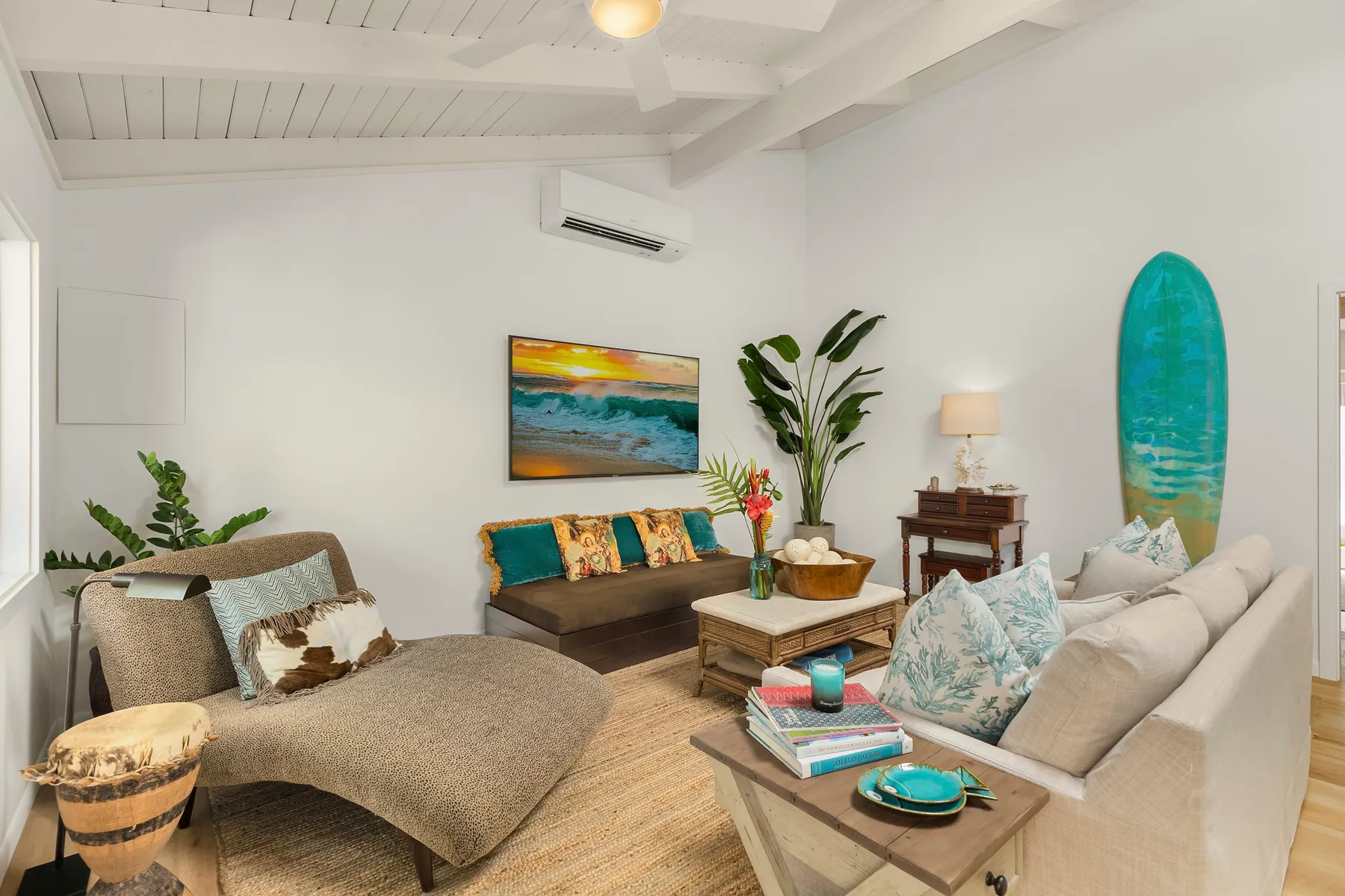Una sala luminosa con asientos acolchados, una mesa baja y arte colorido en la pared.