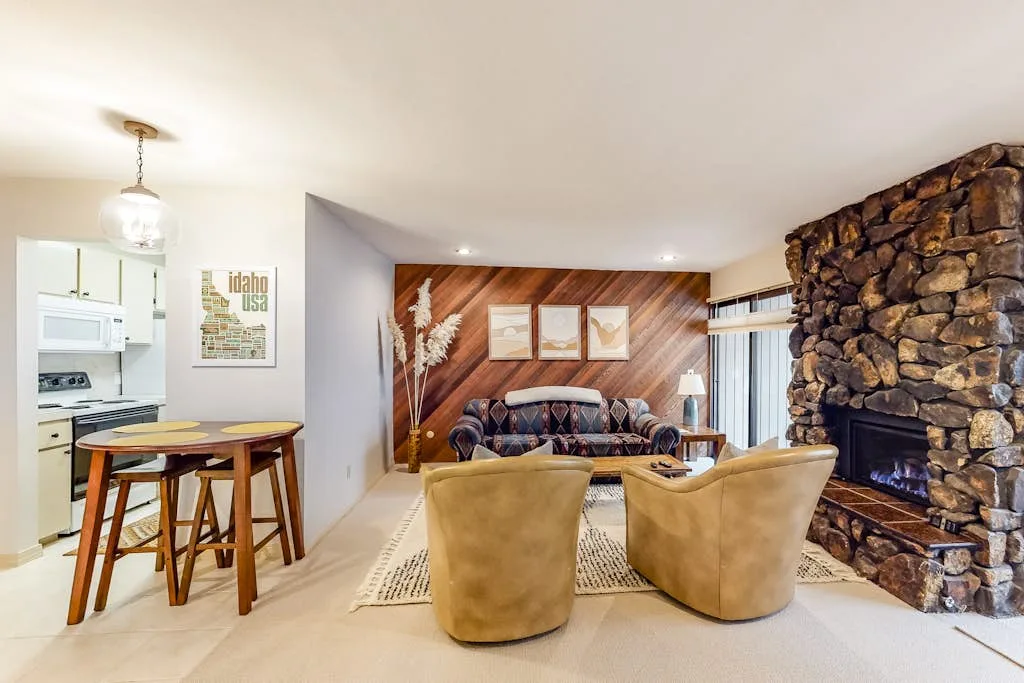 A living room with seating arranged around a fireplace and coffee table.