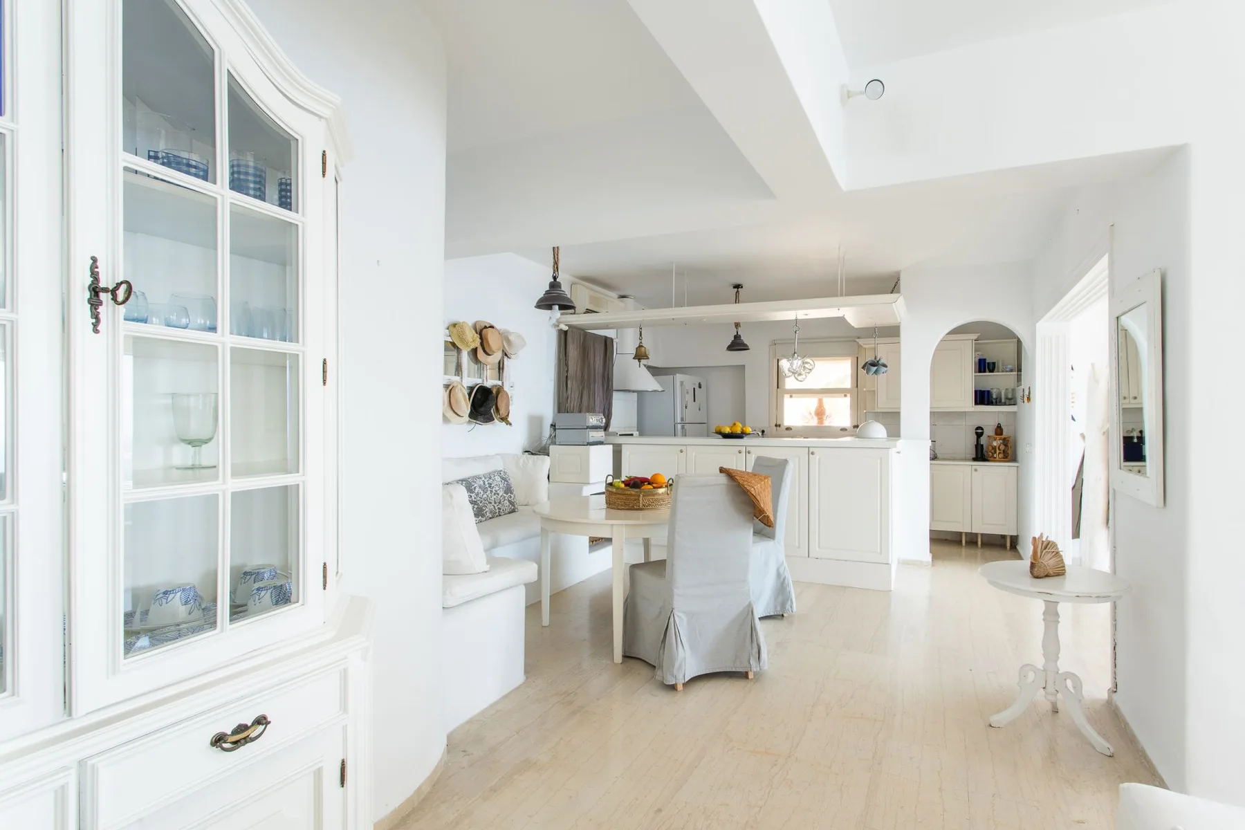 A bright kitchen and dining area with white cabinetry and a table.