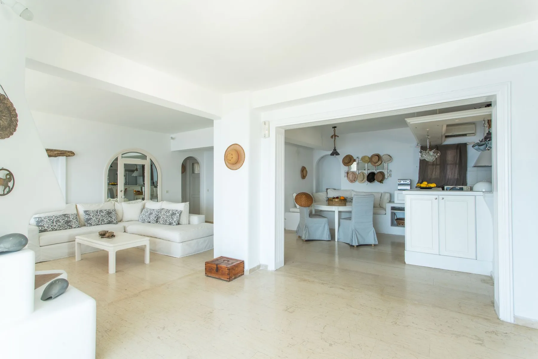 A bright open-plan living room and kitchen with light-colored seating.