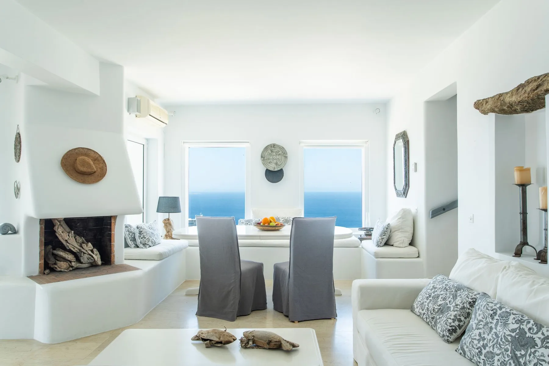 A bright living and dining area overlooks the sea through large windows.