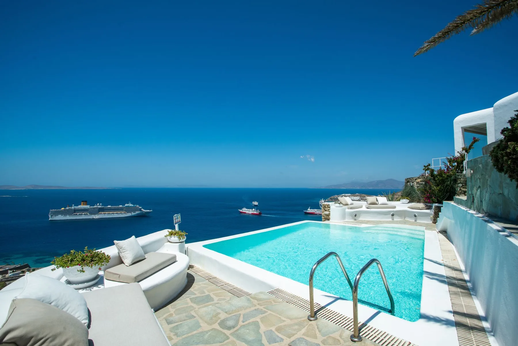 A seaside pool terrace overlooks the blue sea.