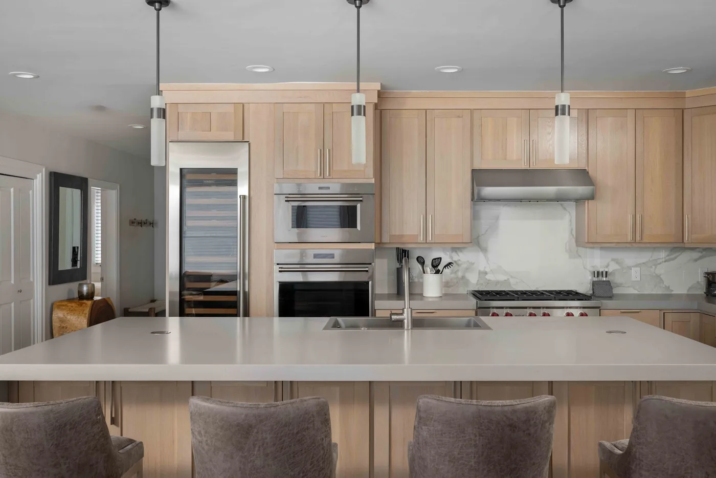 Una cocina luminosa con una isla grande y luces colgantes.