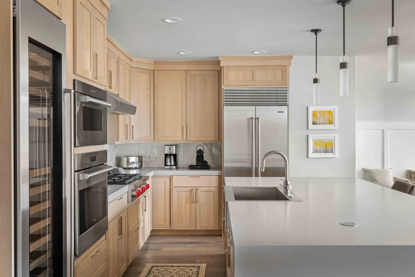 Una cocina moderna con gabinetes de madera clara, electrodomésticos de acero inoxidable y una isla grande.