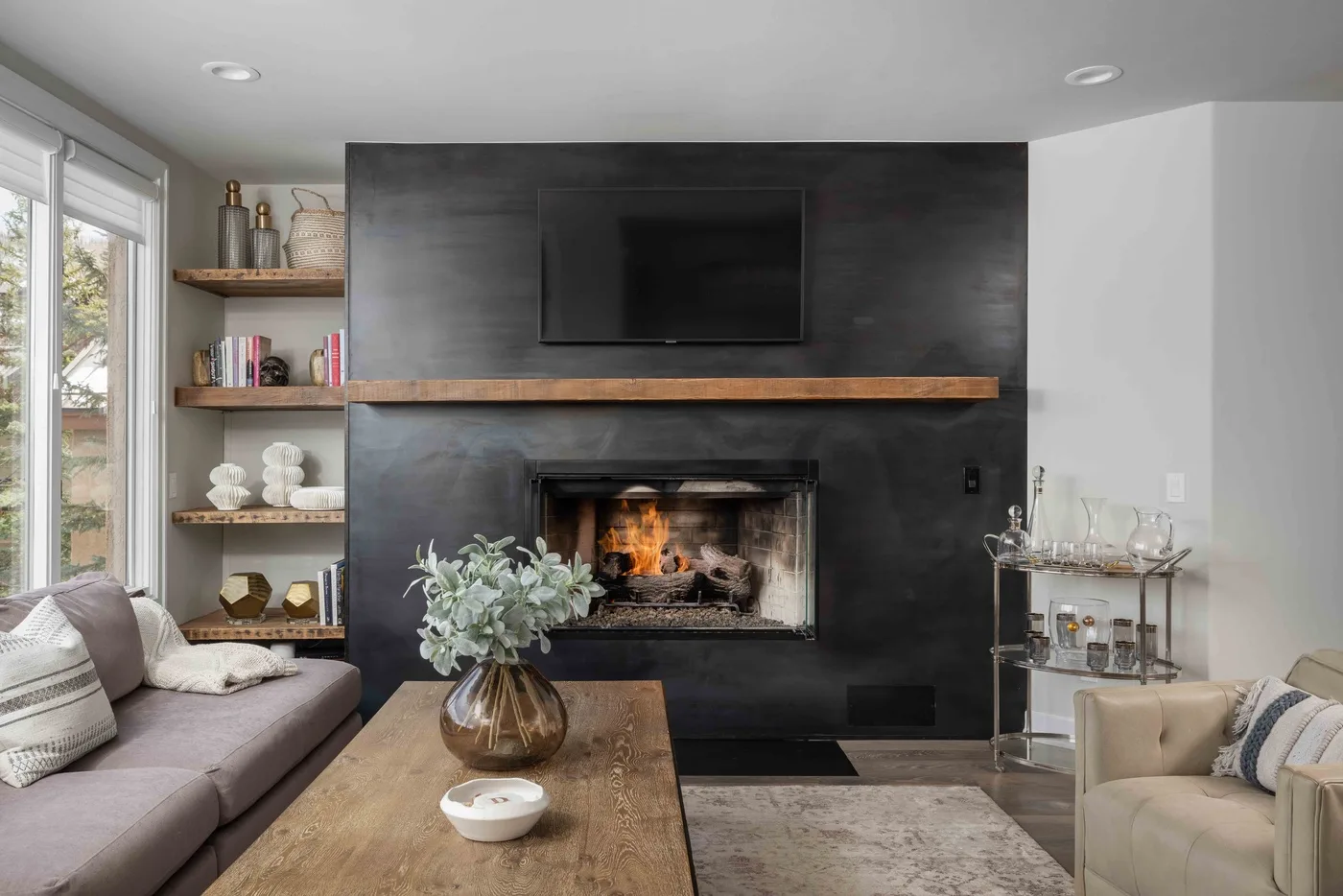 Una sala de estar con asientos dispuestos alrededor de una chimenea y un televisor.