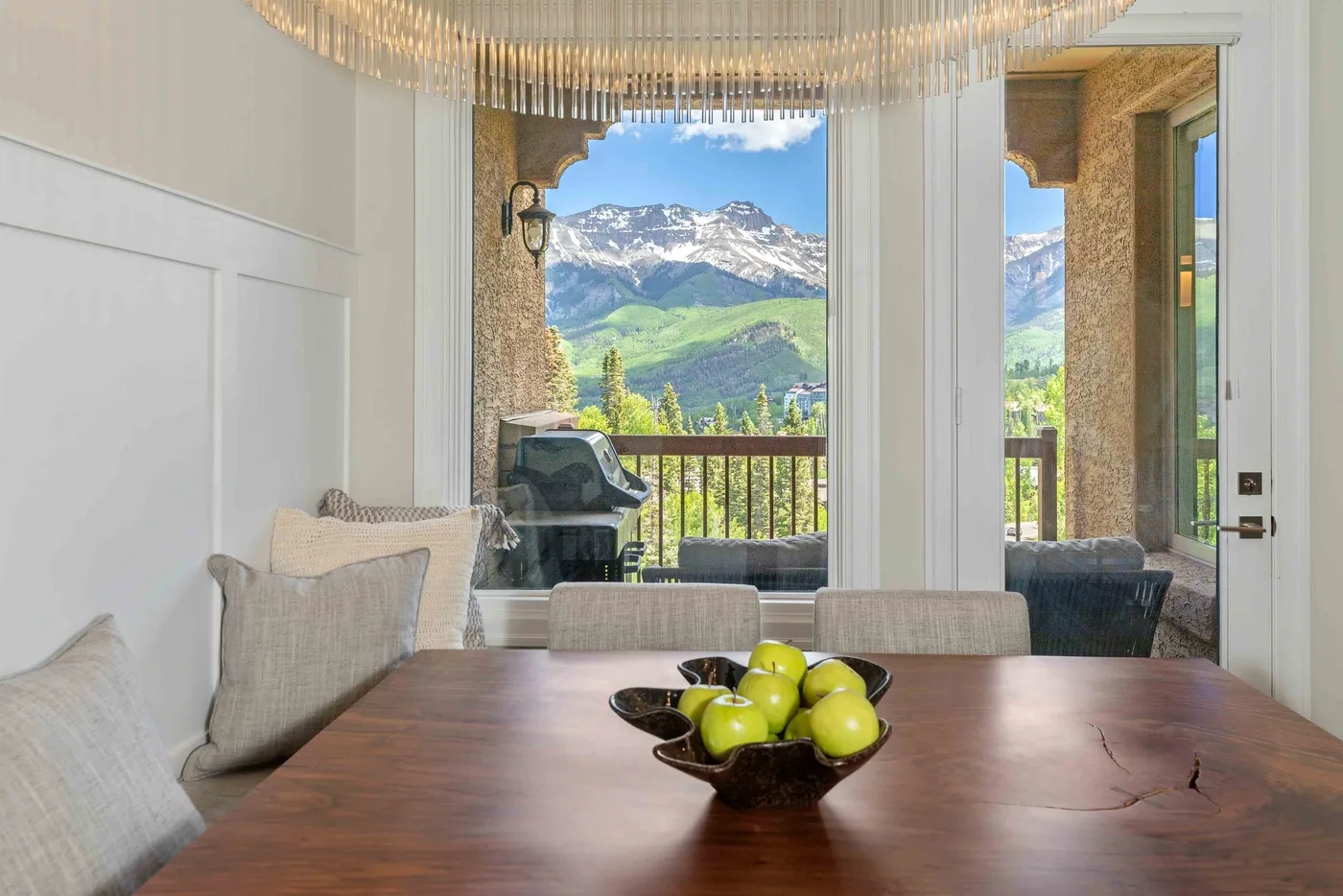 Un comedor da a un balcón con vistas a las montañas.