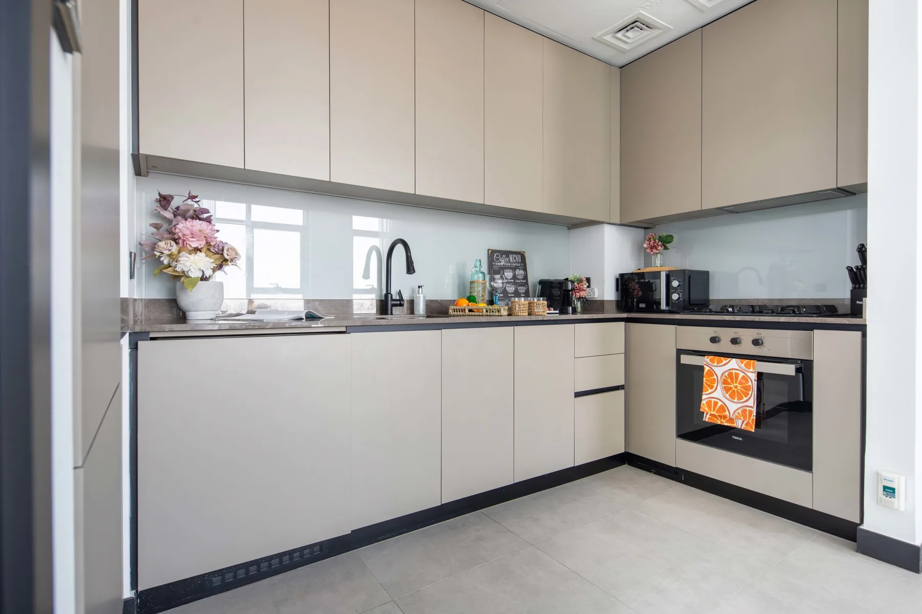 Una cocina moderna con gabinetes claros, una encimera y un horno.