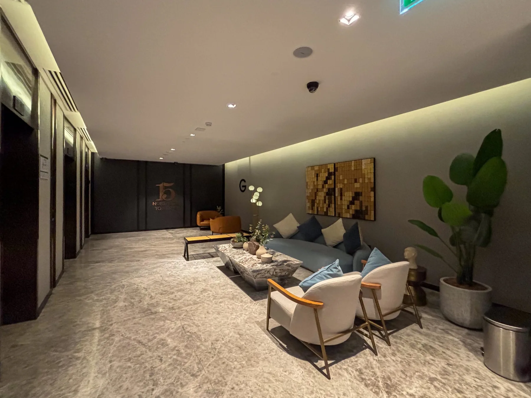 Una zona de estar moderna con asientos, una mesa de centro y una planta grande en maceta.
