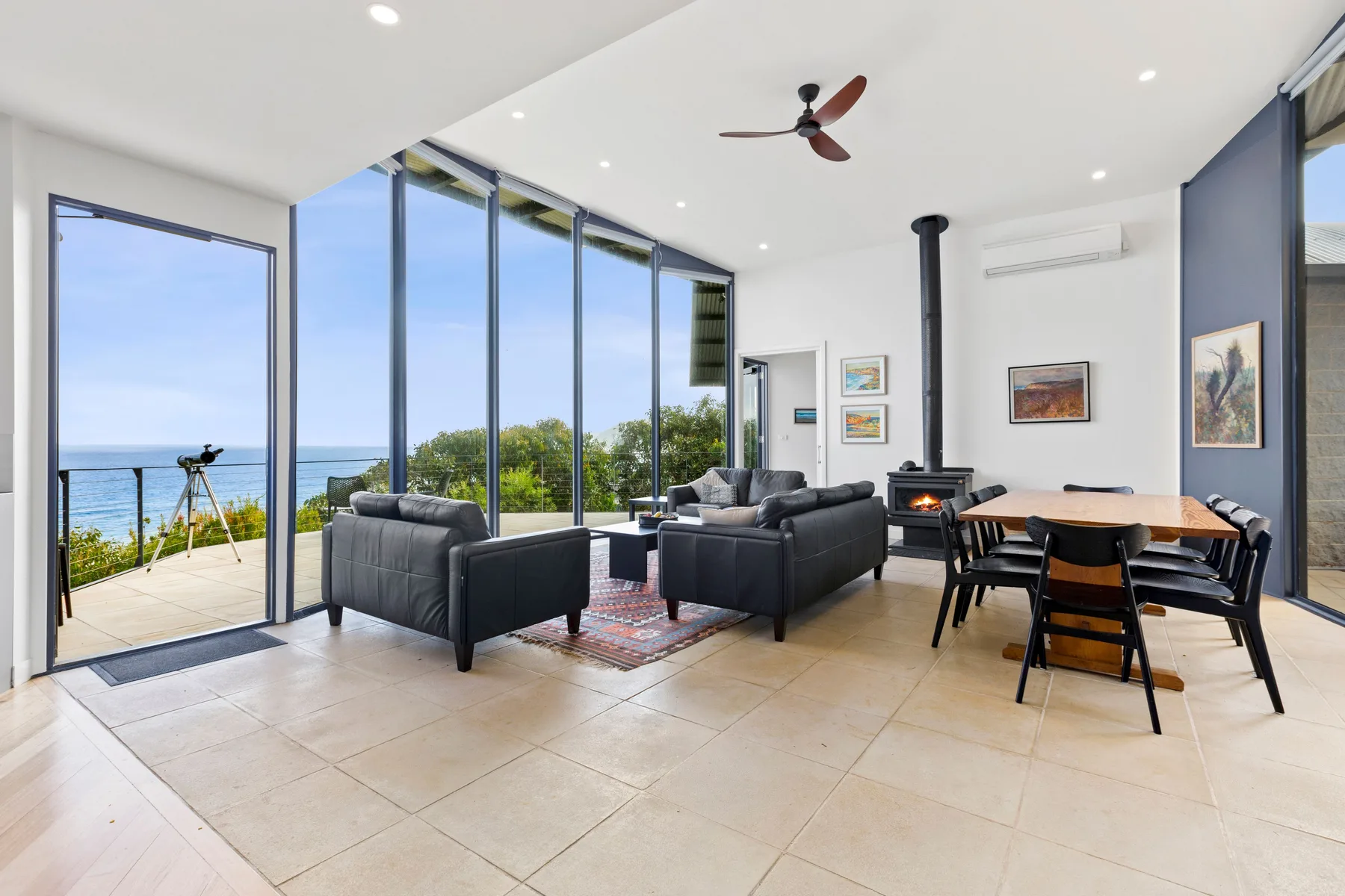 A bright living and dining area opens onto a patio with ocean views.