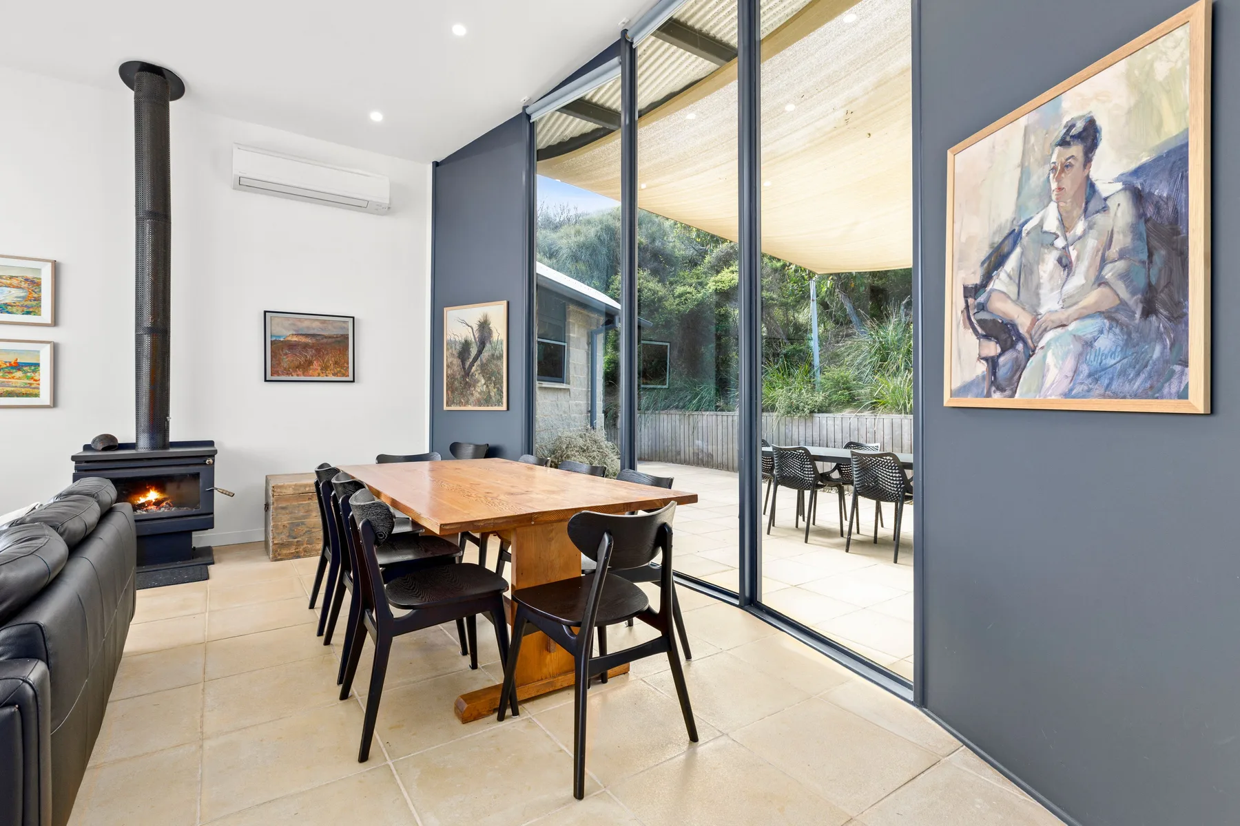 Dining area with a wooden table beside glass doors opening onto a patio.