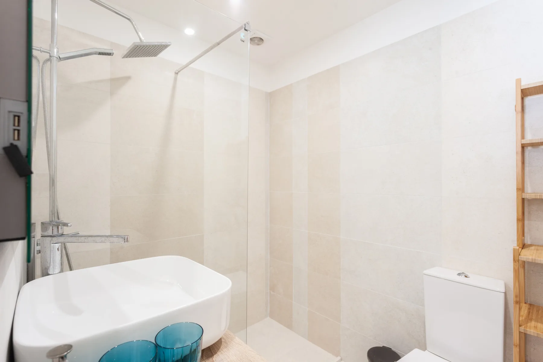 Un baño con ducha y lavabo blanco.