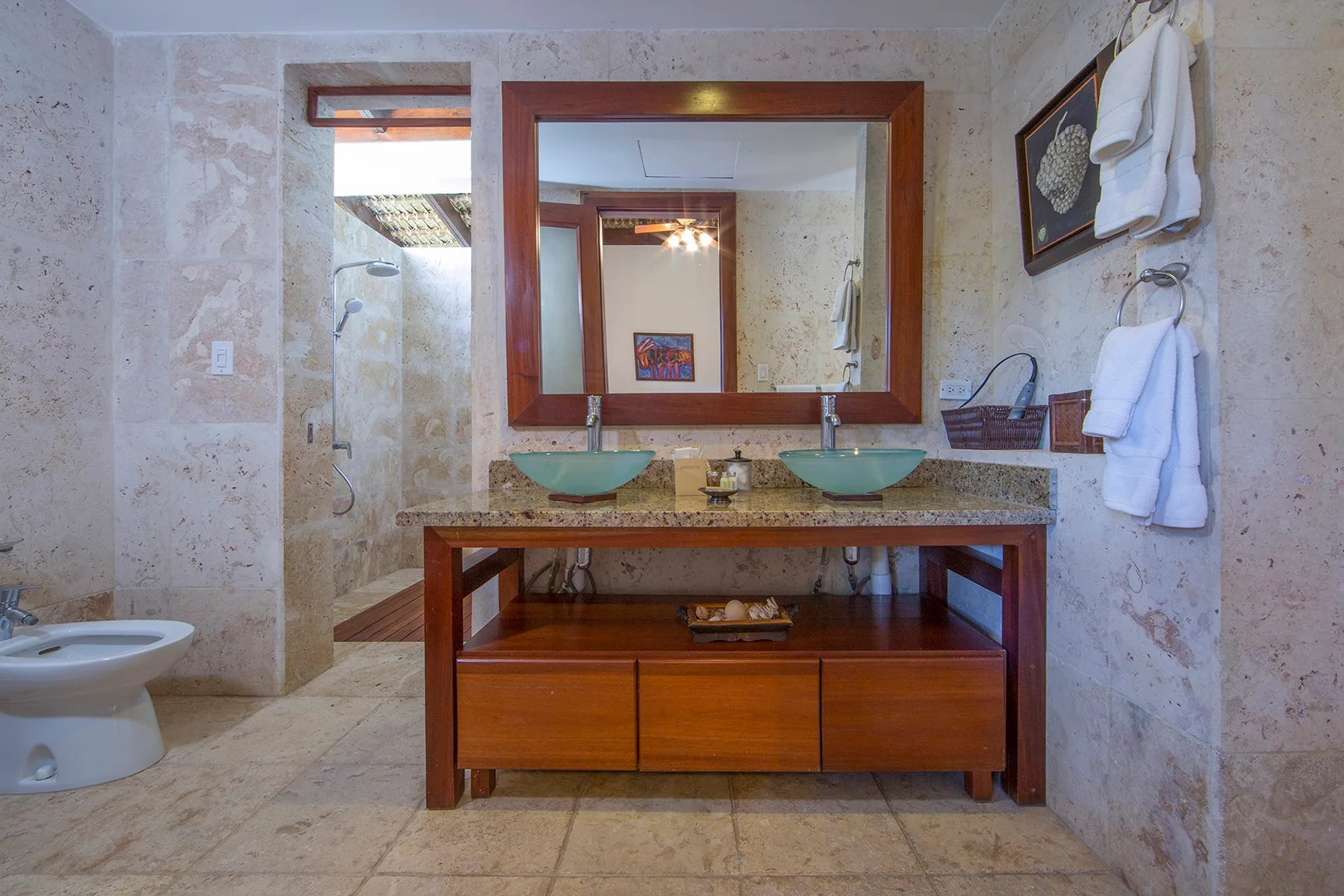 Un baño con un mueble de madera, dos lavabos y un espejo grande.
