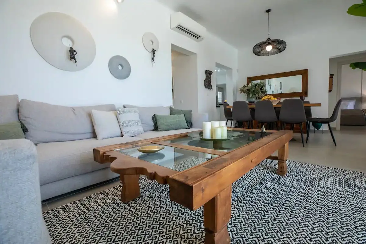 Sala de estar y comedor con sofá seccional y mesa de centro de madera.