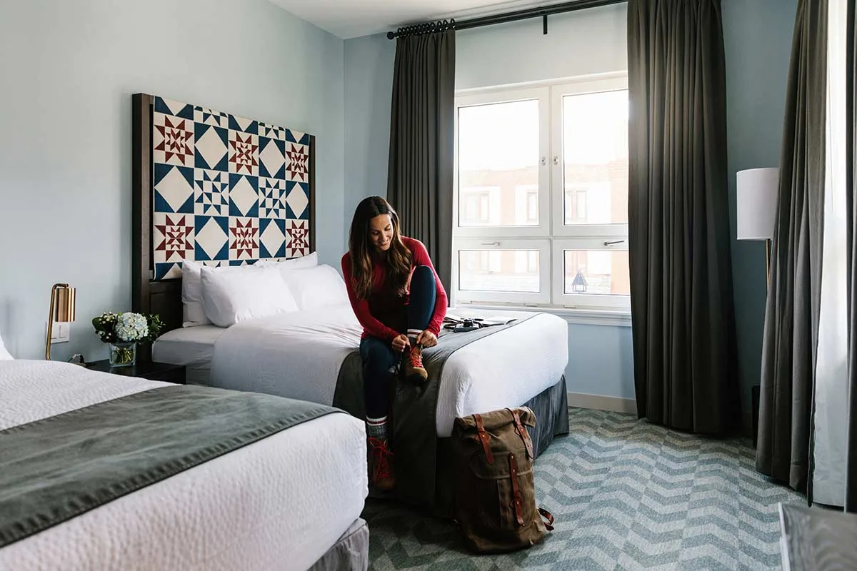 Guest room with a person preparing hiking boots.