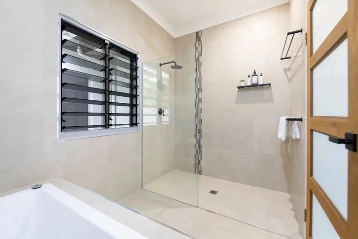 Un baño con ducha de vidrio, bañera y ventana.