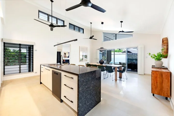 Una luminosa cocina abierta al comedor, con grandes ventanas e isla central.