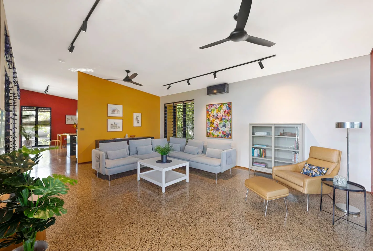 Rodéate de colores vibrantes y comodidad en la elegante sala de estar, refrescada por ventiladores de techo y aire acondicionado, con amplio espacio para reunirse o acurrucarse con un libro.
