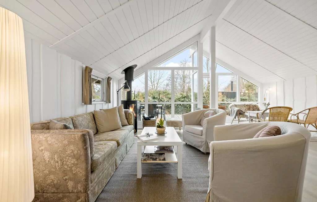 A bright living room with seating around a coffee table and large windows.