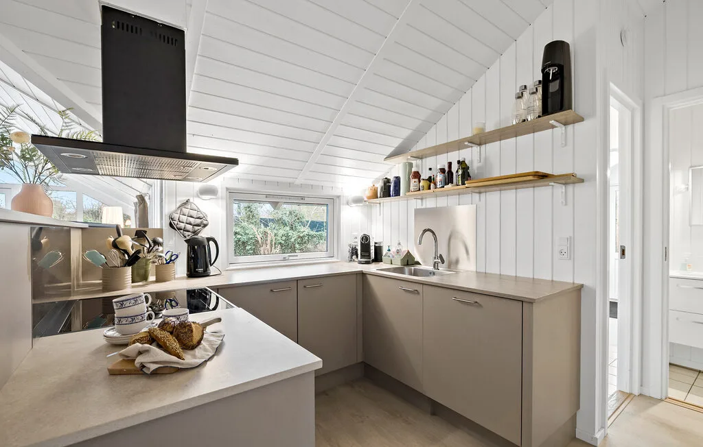 A bright modern kitchen with an island and large windows.