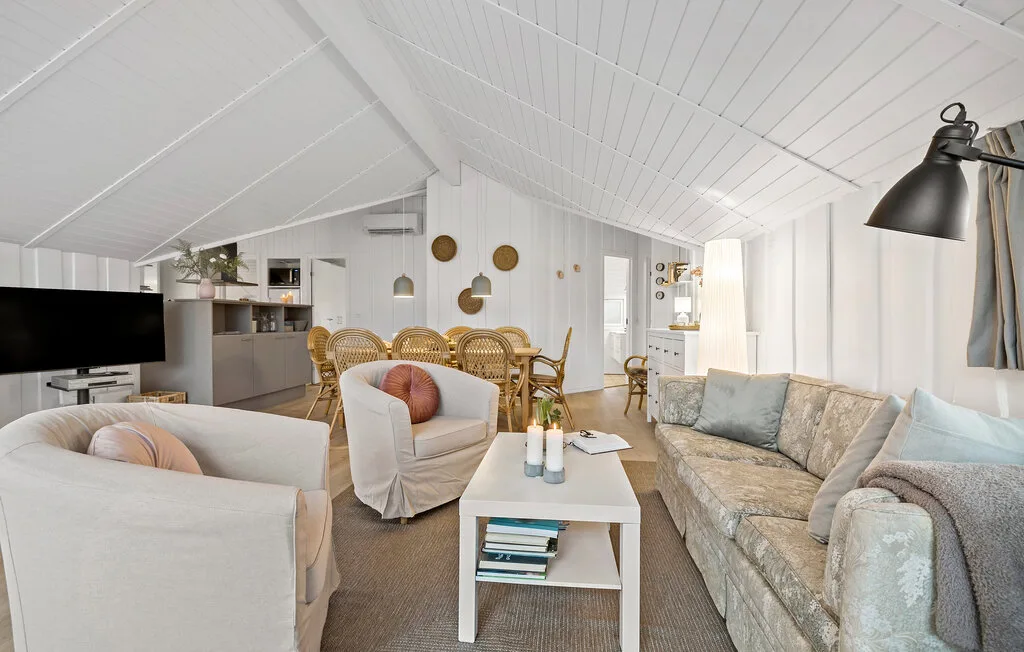 Living room with seating around a coffee table beneath a sloped ceiling.