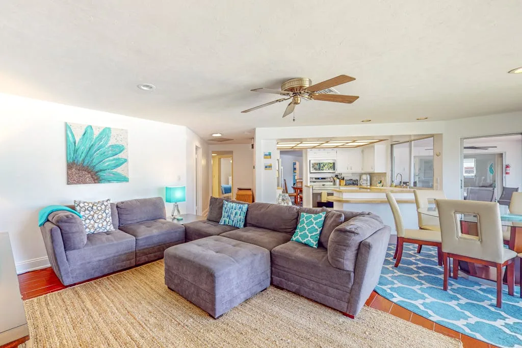 A living room with sectional seating and a dining area.