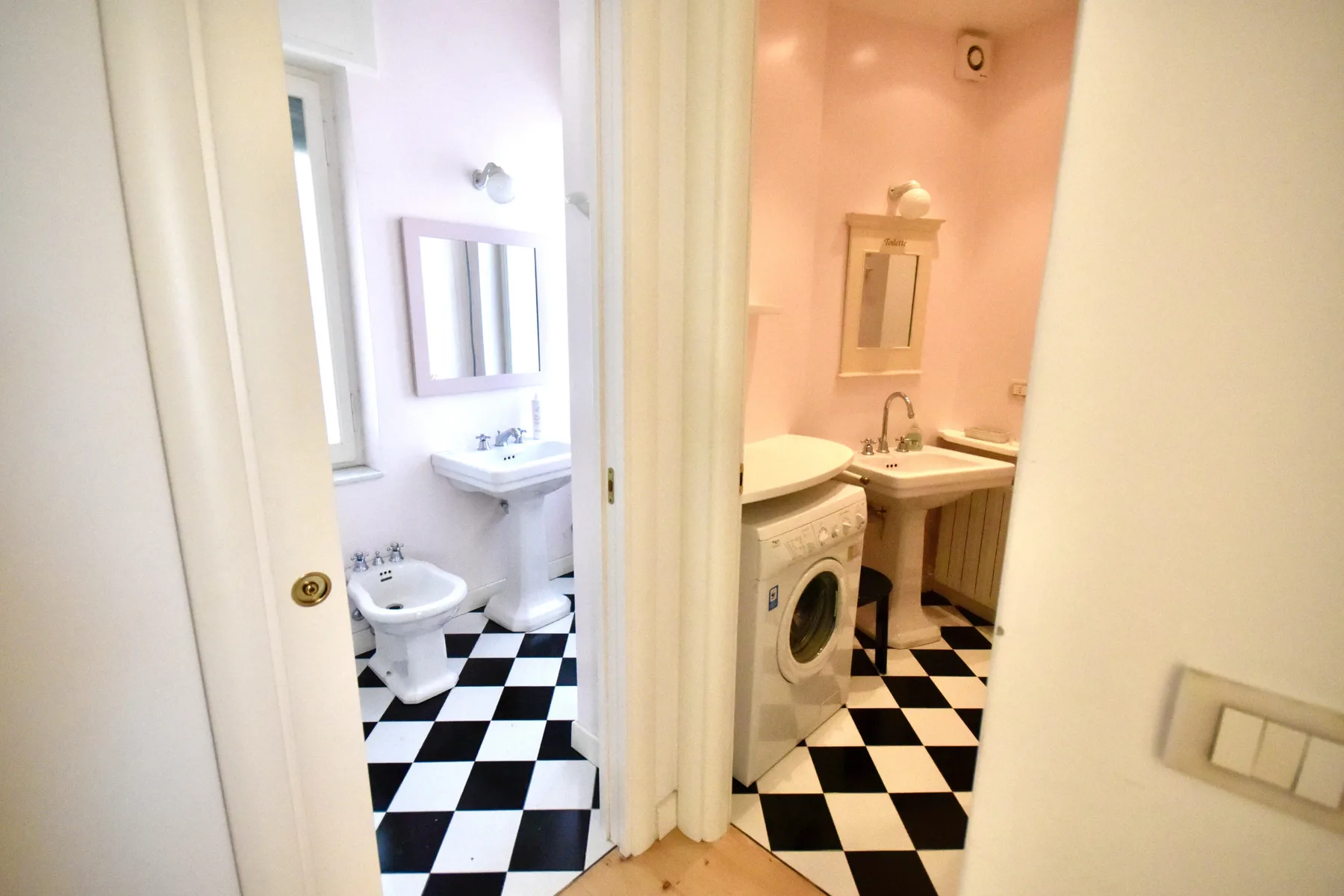 A bathroom with a sink, toilet, and washing machine.