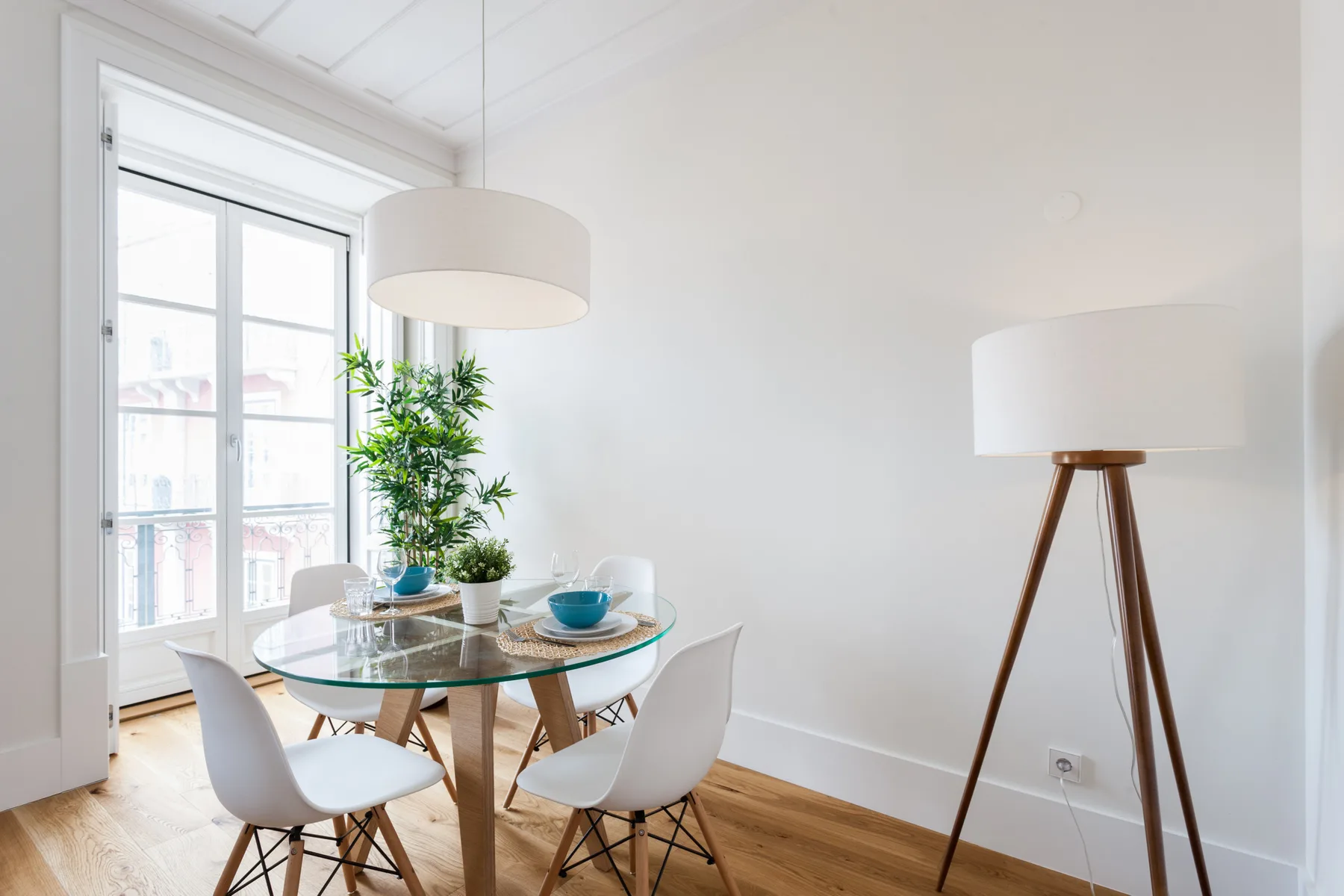 Un comedor luminoso con una mesa de cristal junto a una ventana amplia.
