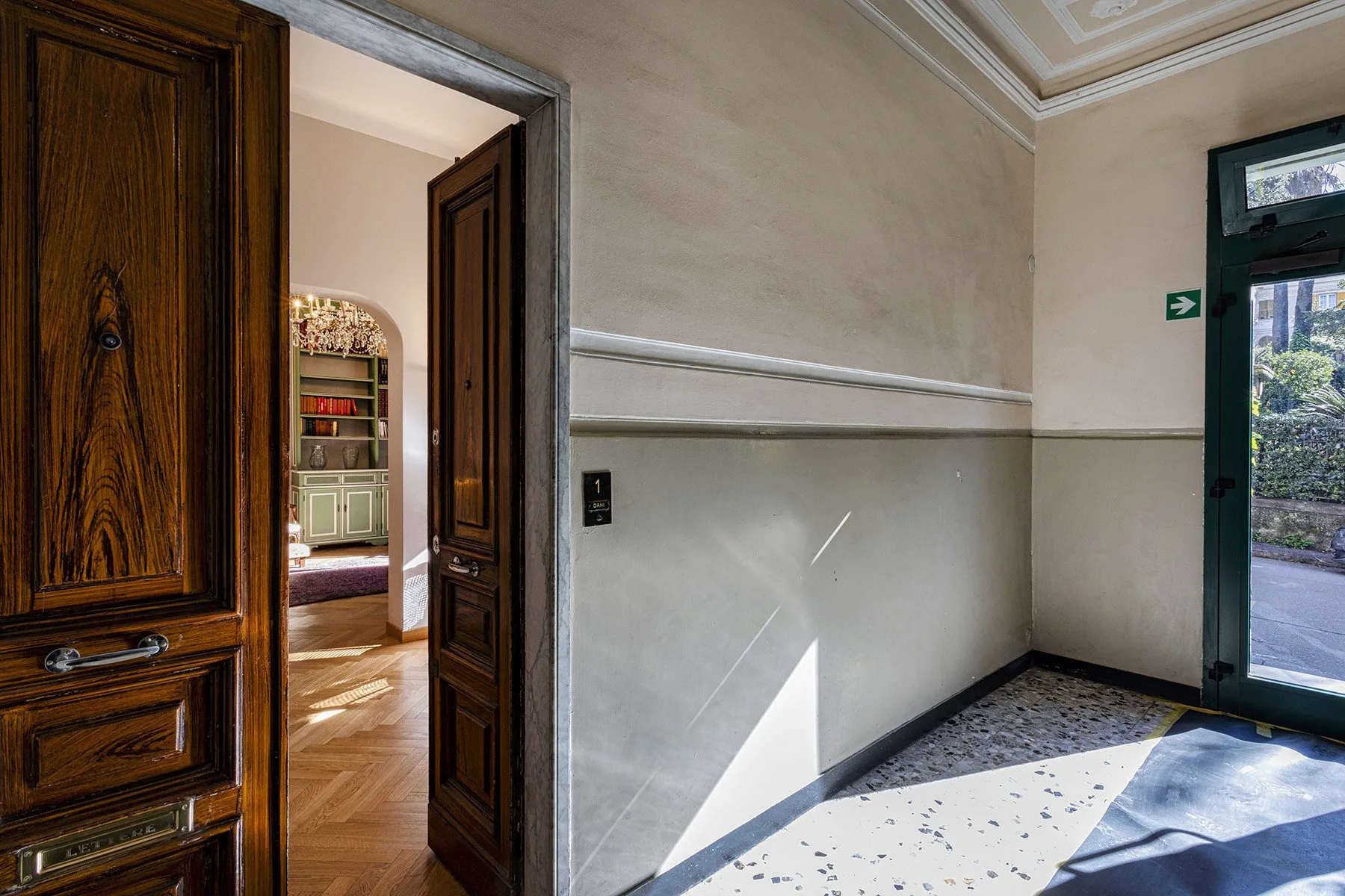 A bright interior hallway with an open doorway and a glazed exterior door.