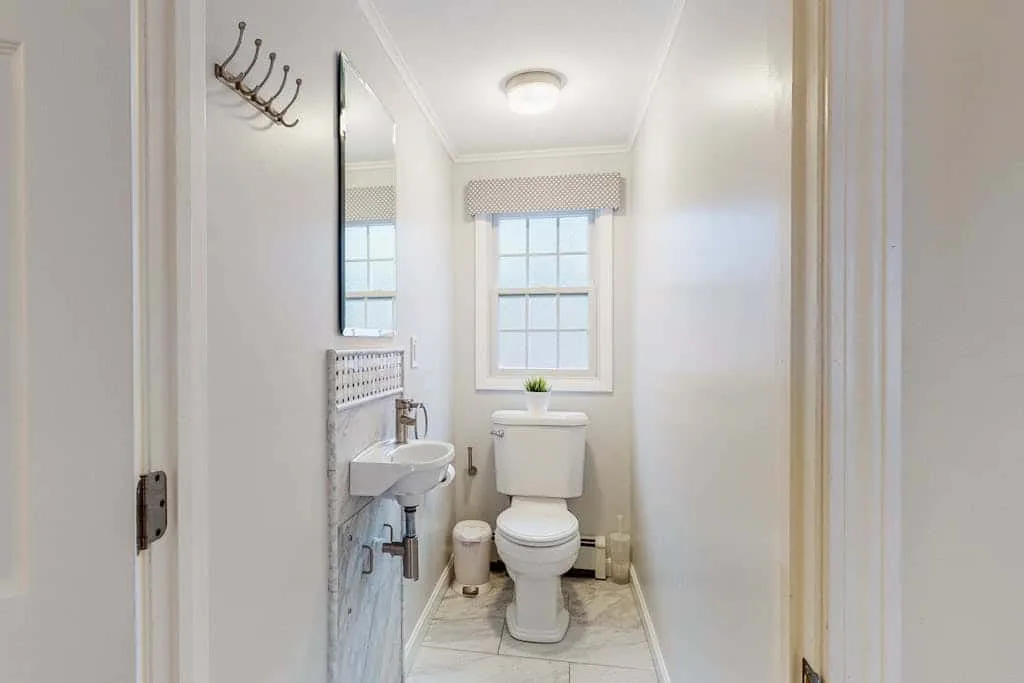 Un baño pequeño con inodoro, lavabo y ventana.