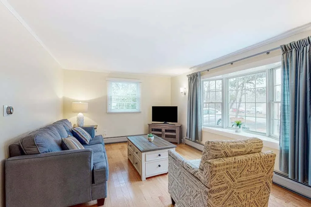 A bright living room with a sofa, coffee table, and large windows.