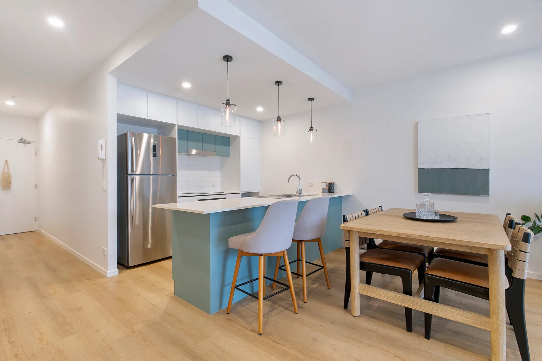 Cocina y comedor de concepto abierto con una barra y una mesa de madera.