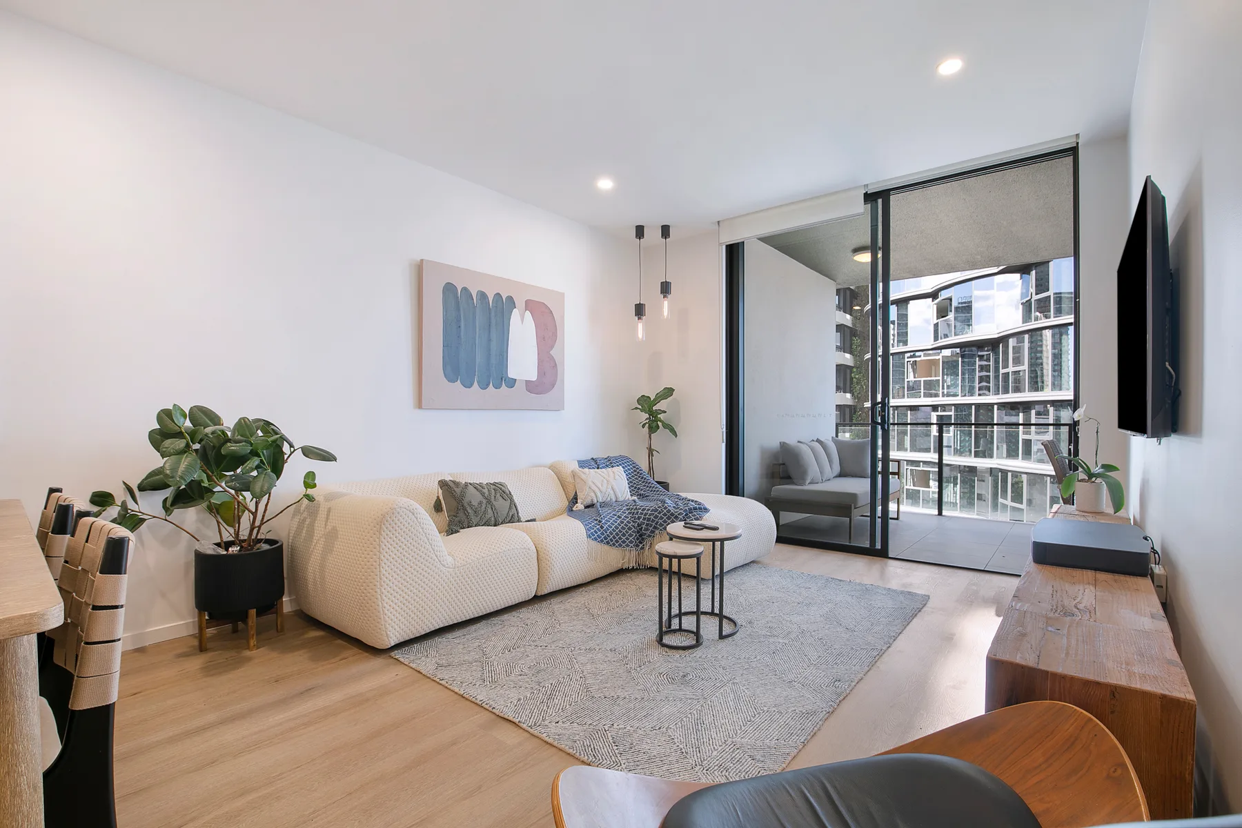 Sink into the inviting living area, where soft contemporary styling, a generous sofa, and a wall-mounted TV create an ideal place to unwind after a day out.