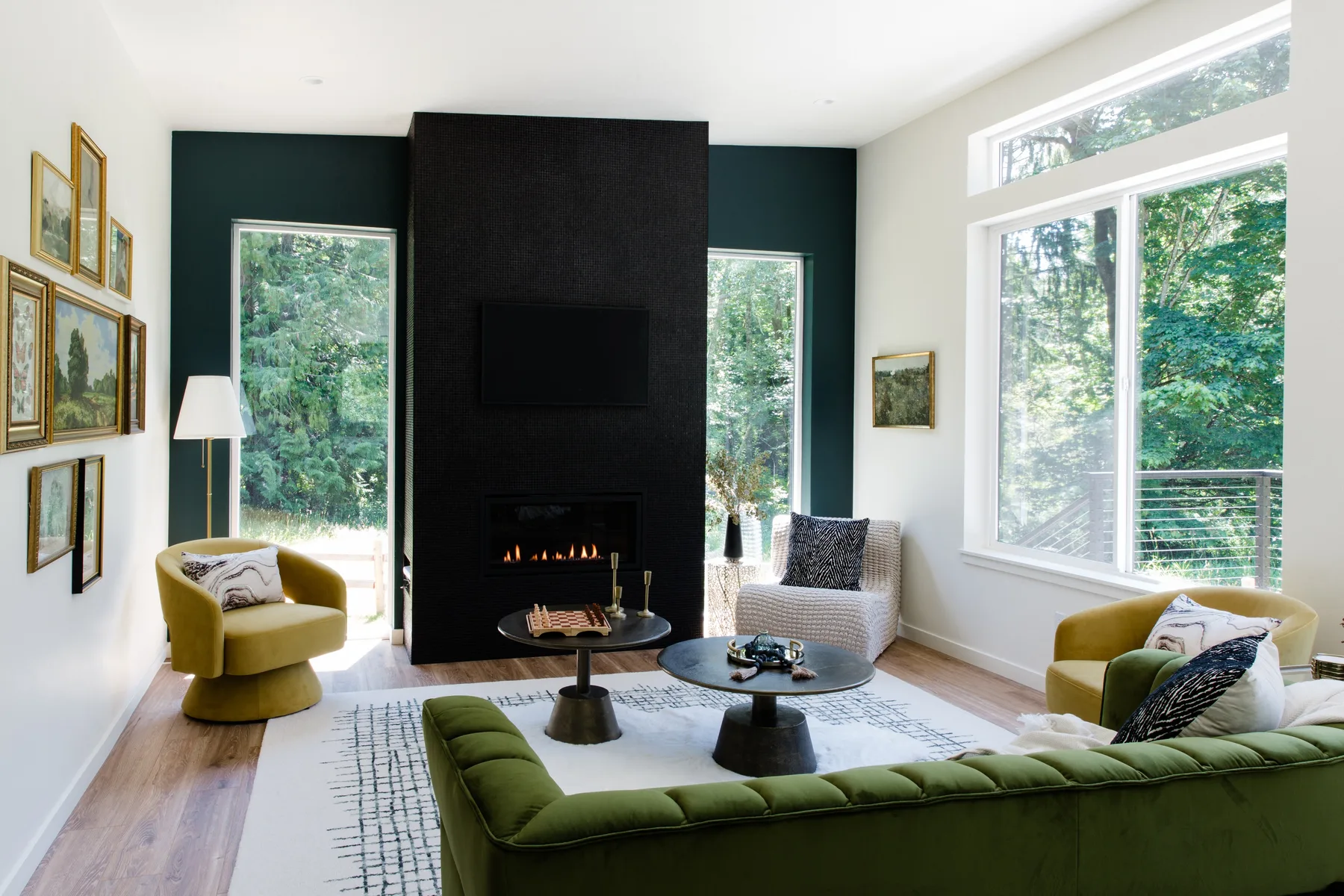 Una sala luminosa con chimenea y asientos junto a grandes ventanas.