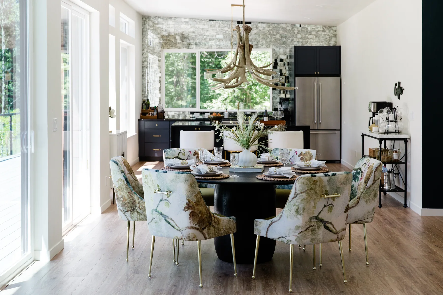 Un comedor luminoso con la mesa puesta junto a una cocina.