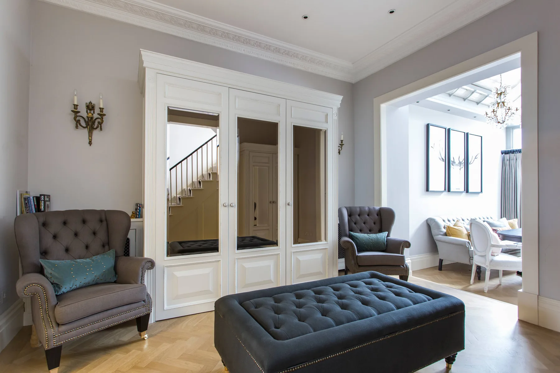 A sitting room with a tufted armchair and matching ottoman.