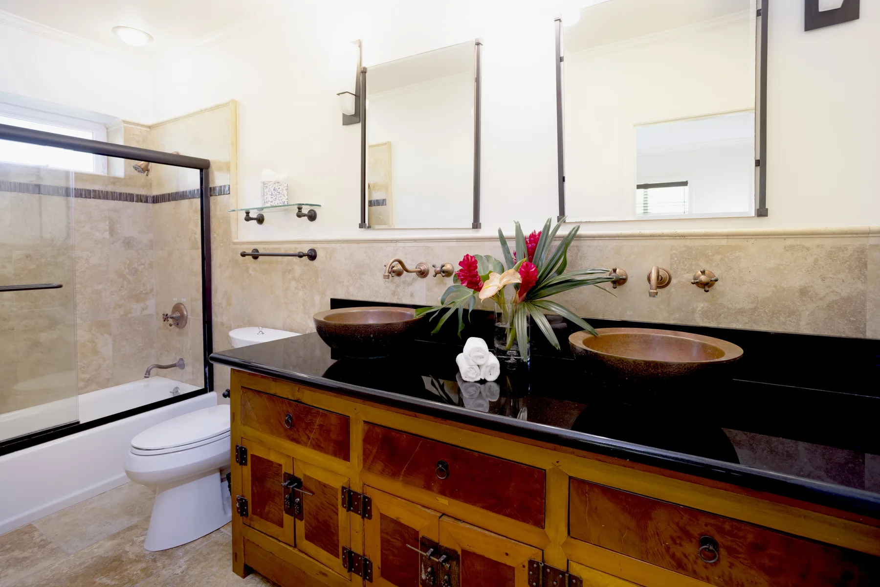 A bathroom with a long vanity, two sinks, and a glass shower.