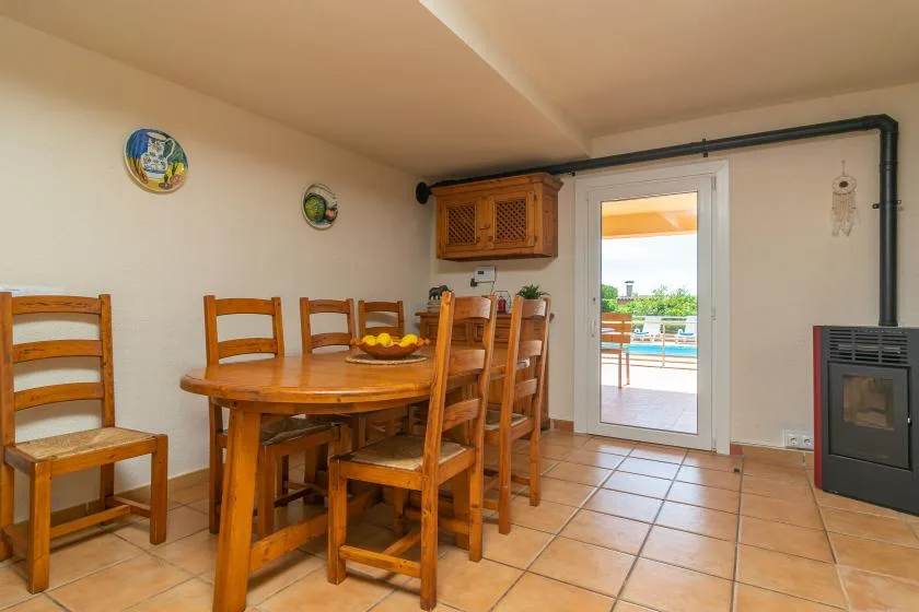 A dining area with a wooden table and chairs beside a glass door.