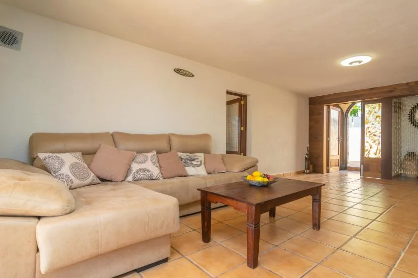 A living room with beige seating and a wooden coffee table.