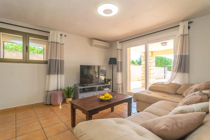 A living room with seating, a television, and a coffee table.