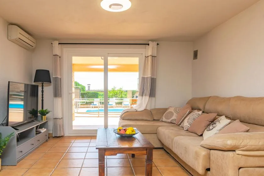 A living room with a sectional sofa and sliding glass doors opening onto a balcony.