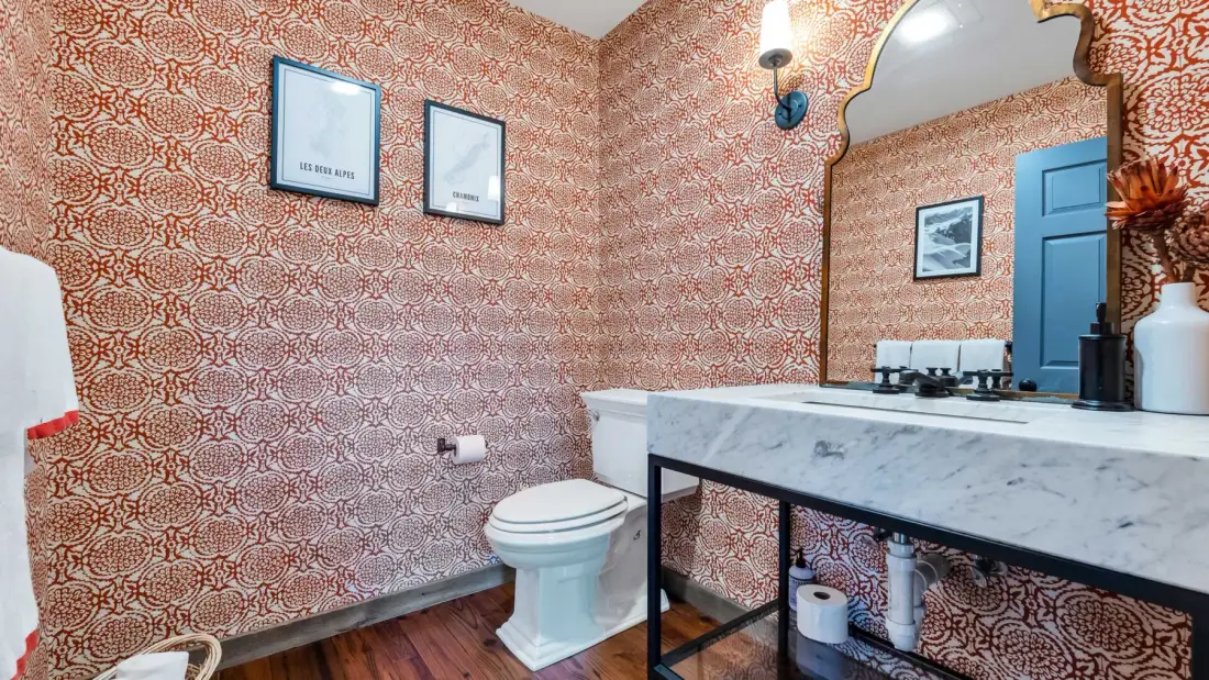 Un baño estampado con inodoro, lavabo y espejo.