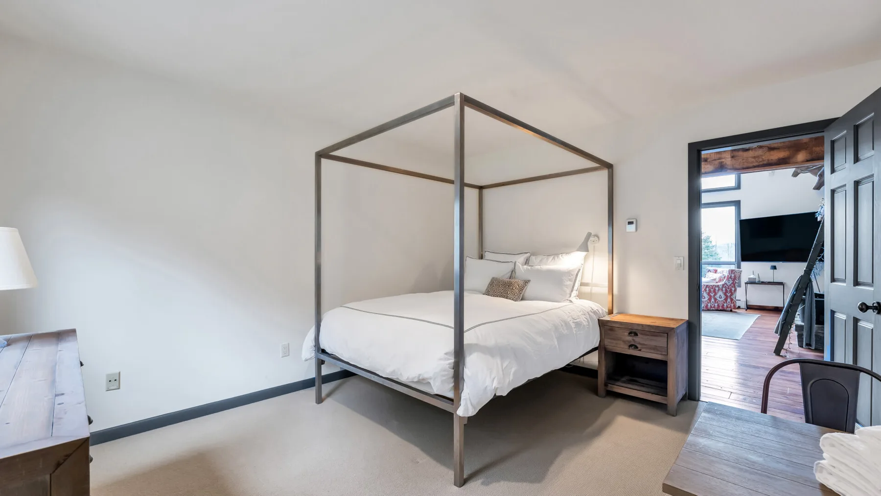 Un dormitorio con una cama con dosel y una mesita de noche de madera.