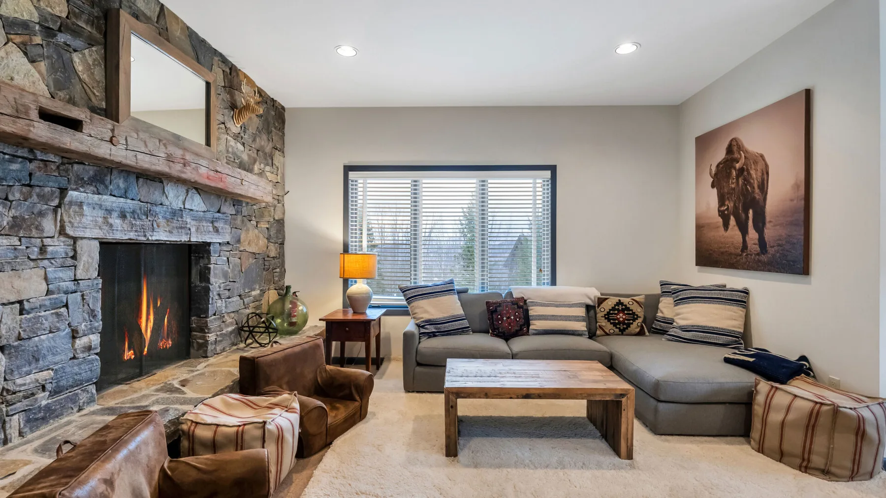 Una sala de estar con chimenea de piedra, asientos y una mesa de centro.