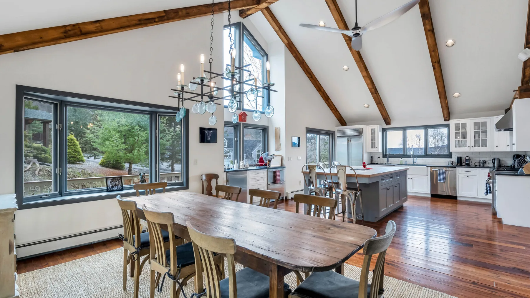 Una cocina abierta y zona de comedor con una mesa larga de madera e isla.