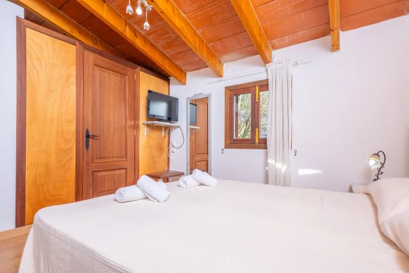 Un dormitorio con una cama grande, puertas de madera y una ventana.