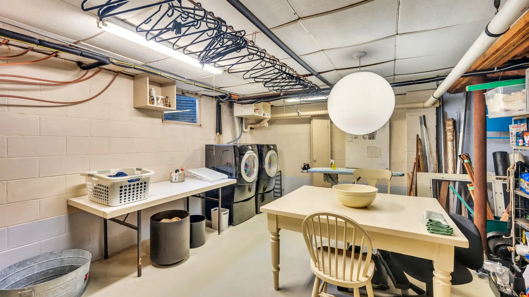 A laundry and utility room with washing machines and a table.